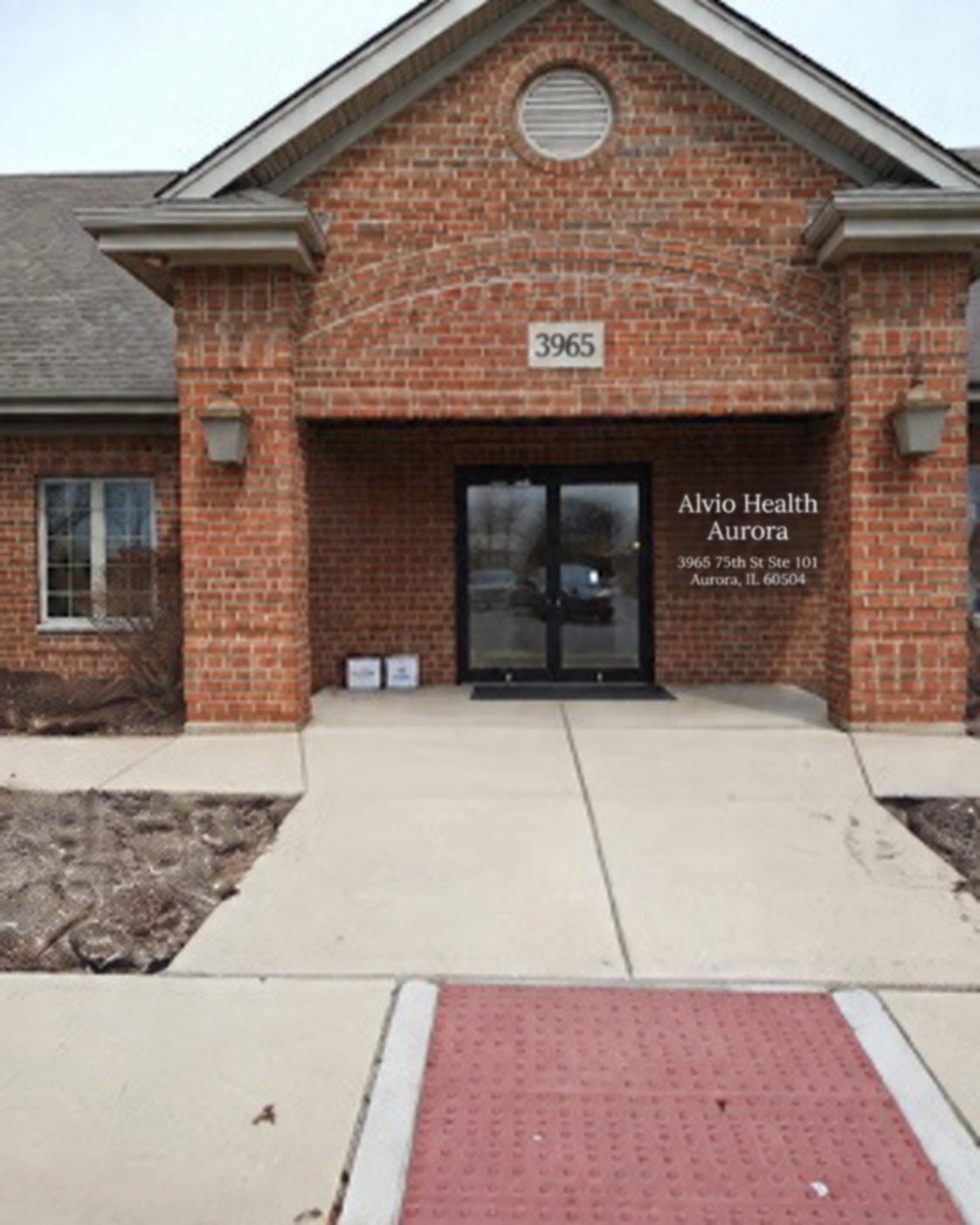The main entrance under a brick archway, with the suite signage beside the doors